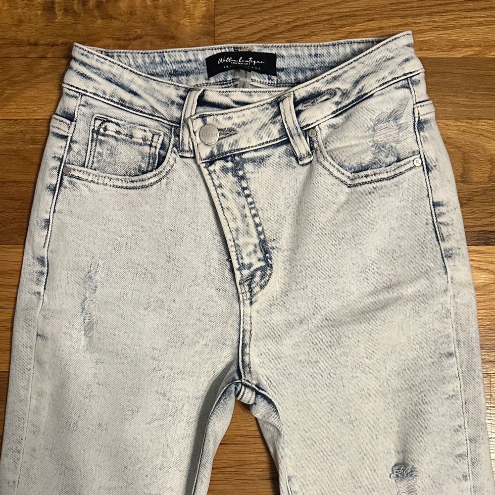 Risen Brand High Rise distressed flared jeans. Asymmetrical waistband.